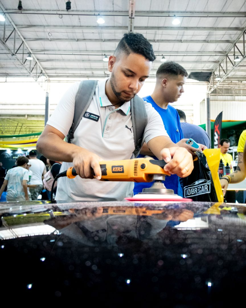 Especialista realizando demonstração técnica na feira para estética automotiva e lava-rápido.
